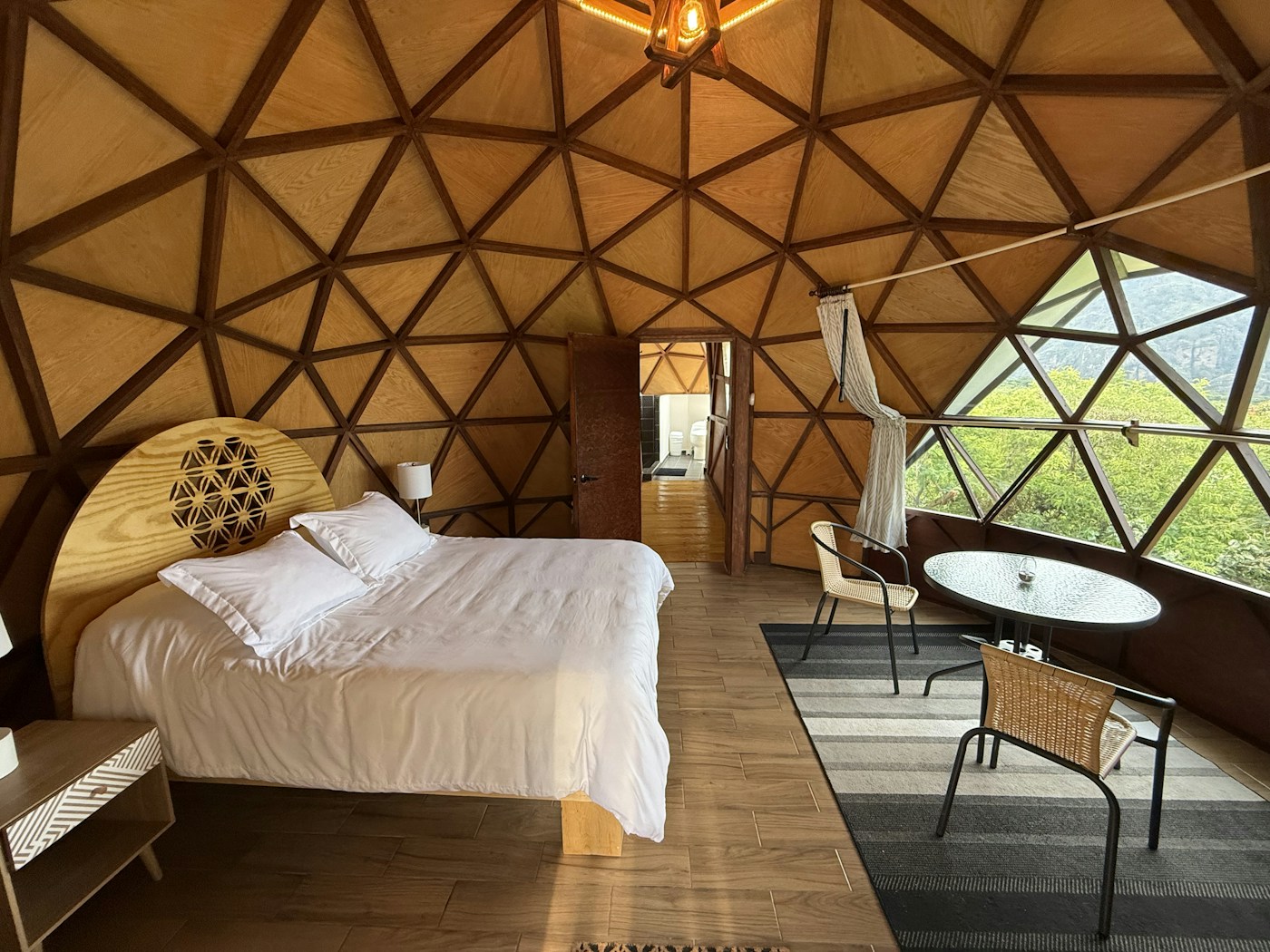Interior del Domo Orión con ventanal geométrico y vista a la montaña